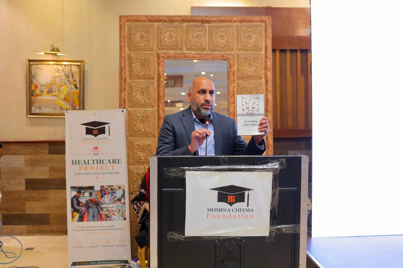 Dr Fareed Cheema holding Everything Else Follows at the launch in Lahore